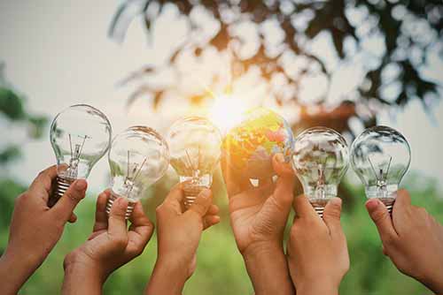 children show hand with light bulb and world toy concept solar energy and sustainability